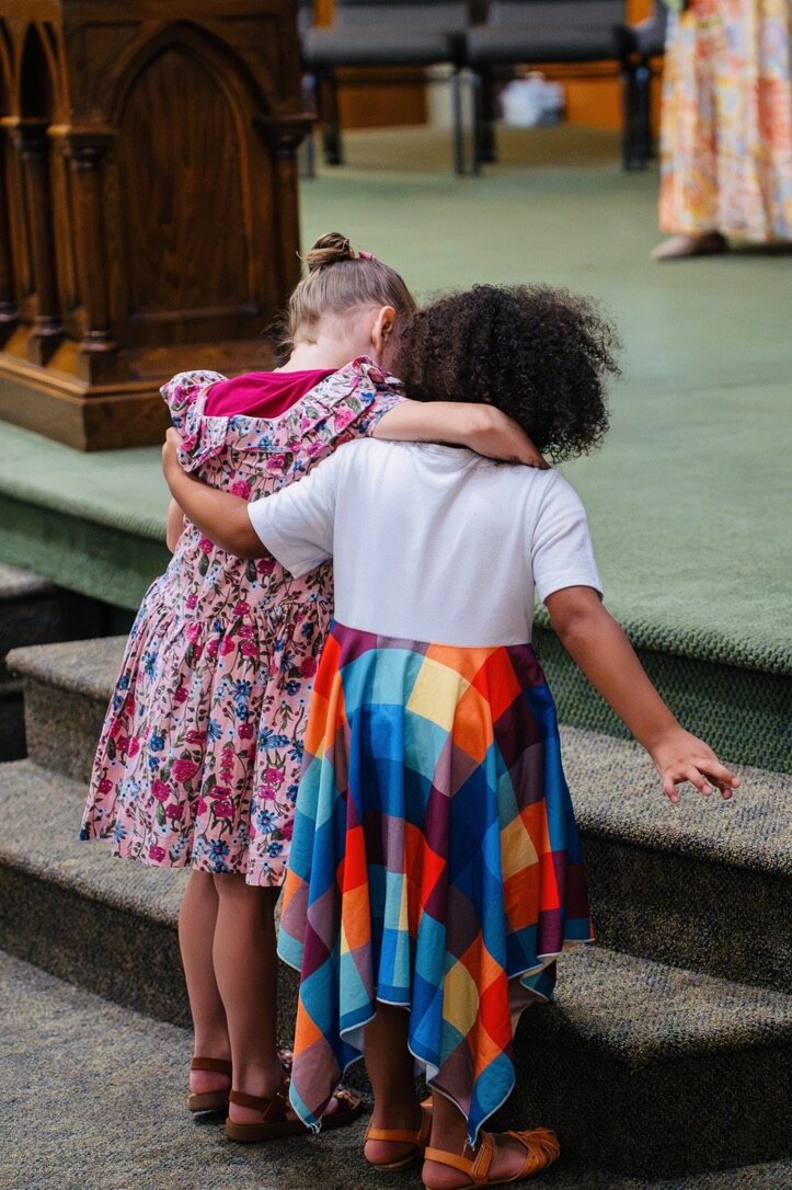 Two children embracing after a gathering at Christian Life Assembly