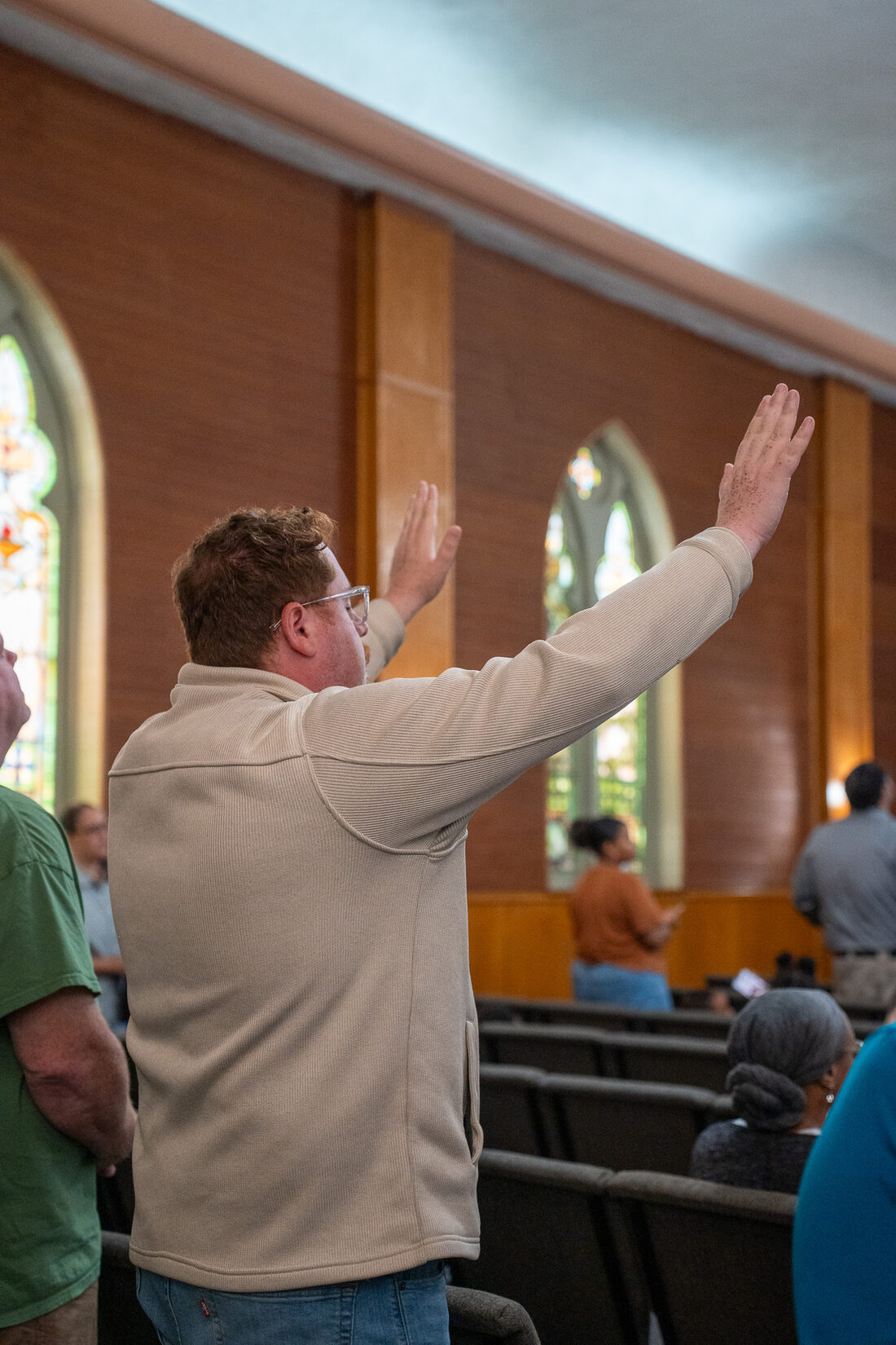 A worshiper with hands lifted at CLA