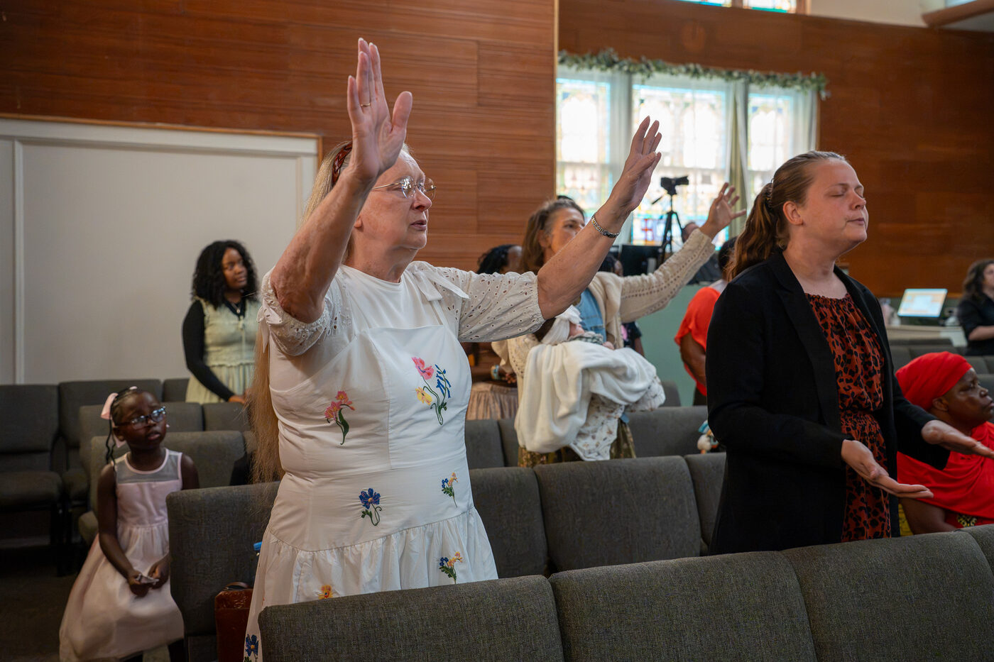 A woman worshiping with hands raised at CLA