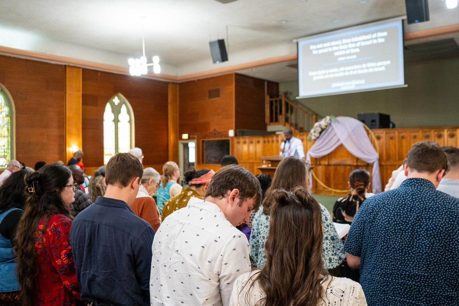 People standing in the CLA Syracuse sanctuary during a Sunday gathering